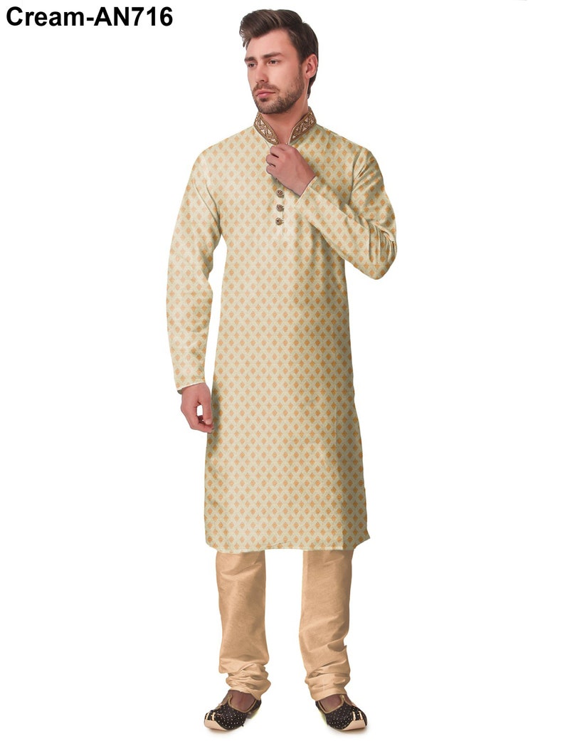 May include: Cream-colored kurta pajama set. The long-sleeved kurta features a subtle geometric pattern and decorative collar. The matching pajama pants and embroidered shoes complete the traditional Indian outfit.