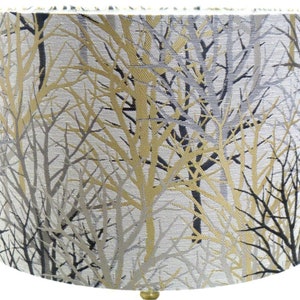 May include: A white lampshade with a gold and black tree pattern.