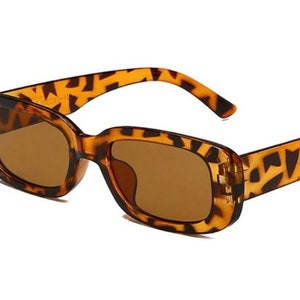 Op de afbeelding: Bruine en zwarte vierkante zonnebril met schildpadpatroon en bruine glazen.