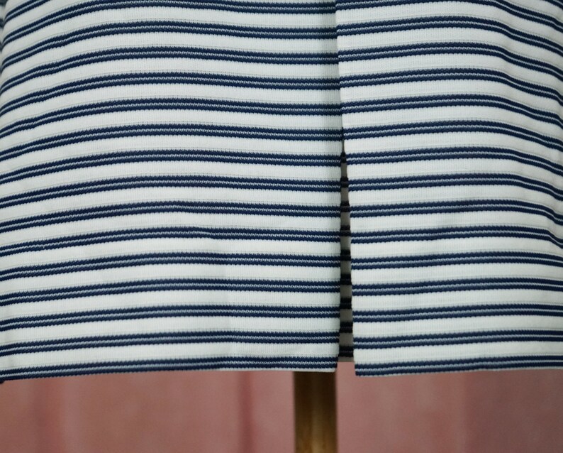 May include: White and navy blue striped fabric with a vertical seam down the centre.