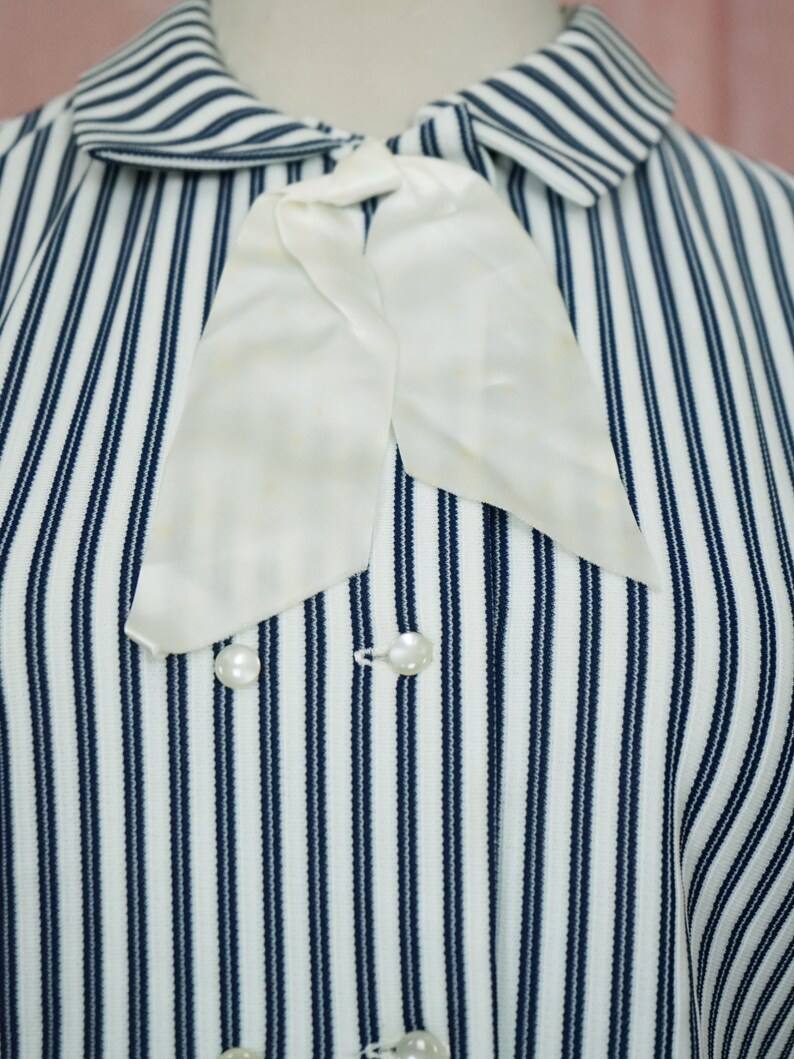 May include: A white and blue striped shirt with a white bow tie and pearl buttons.