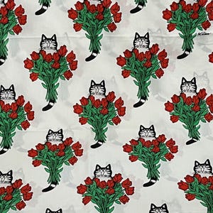 May include: A white fabric featuring a repeating pattern of black and white cats holding large bouquets of red tulips with green stems and leaves. The cats have wide eyes and black-tipped tails, arranged in a grid across the material.