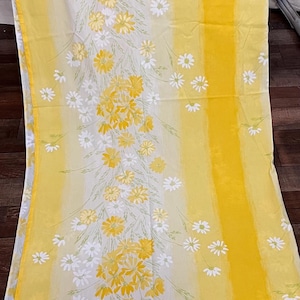May include: A long rectangular fabric panel featuring a vertical pattern of yellow and white daisies on a background of alternating solid yellow stripes and pale yellow and white vertical bands, creating a bright floral design.