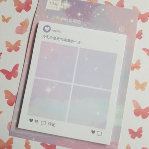 May include: A pastel-coloured notepad with a social media-style design, featuring a square grid and Chinese text. The notepad is layered over a larger sheet with a starry sky design and butterfly pattern. The text includes the word "lovely".