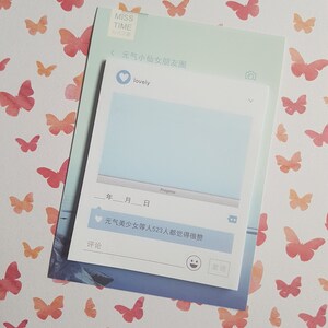 May include: A stationery set with a social media theme, featuring a light blue notepad with Chinese text. The background is decorated with watercolor butterflies in pink and orange hues. The notepad has a digital interface design.