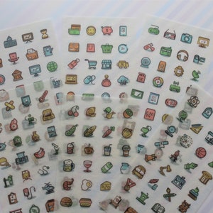 May include: Sheets of stickers with colourful, cartoon-style icons. The stickers depict various objects and symbols, including a shopping cart, a globe, a thermometer, and food items. The stickers are on a white background.