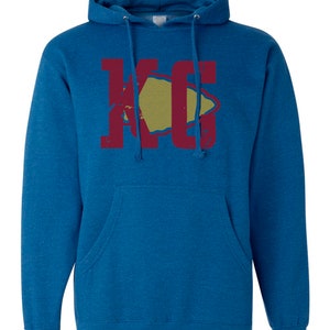 May include: A blue hooded sweatshirt with a red and yellow graphic of the letters "KC" with a stylized arrowhead shape.