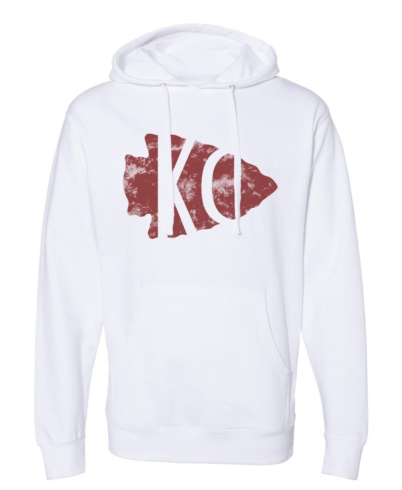May include: White hooded sweatshirt with a red arrowhead design featuring the letters "KO" in white.