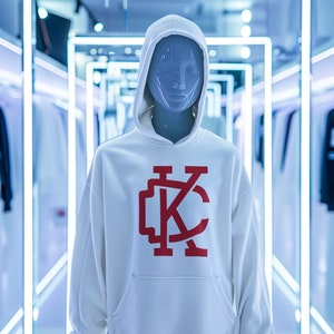 May include: White hooded sweatshirt with a red "KC" logo on the front. The sweatshirt is on a mannequin in a store setting.