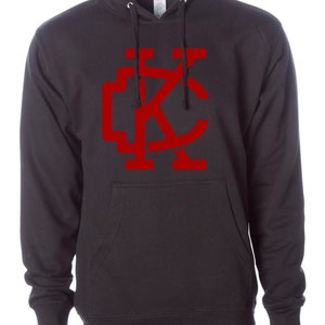 May include: Black hooded sweatshirt with a red "KC" logo on the front.