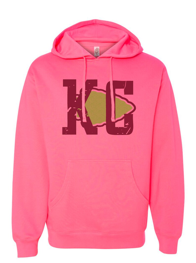 May include: A pink hoodie with a maroon "KC" graphic featuring a gold arrowhead.
