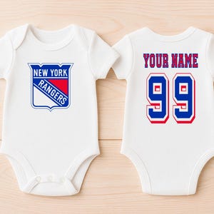 May include: White baby bodysuit featuring the New York Rangers logo on the front. The back of the bodysuit displays the text "YOUR NAME" above the number "99" in blue and red.