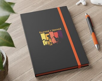 May include: Black notebook with an orange elastic closure and a colorful mountain scene with the text "Onward & Upward".