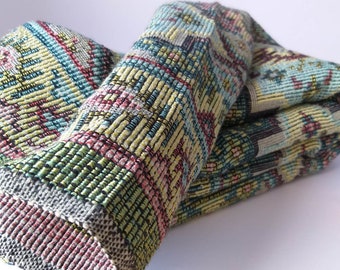 Peut inclure: Un tissu plié avec un motif géométrique coloré dans des tons de bleu, vert, jaune et rose.