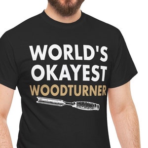 May include: A black t-shirt with the text "WORLD'S OKAYEST WOODTURNER" in white and a stylized image of a wood chisel in brown.