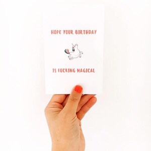 Puede incluir: Una tarjeta blanca con una ilustraci&oacute;n de unicornio rosa y el texto "Espero que tu cumplea&ntilde;os sea jodidamente m&aacute;gico."