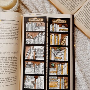 May include: Two bookmarks with a bookshelf design. Each bookmark has a black background with the text "100 CLASSICS" at the top. The shelves are filled with book titles, and the design includes a candle and a cup of coffee.