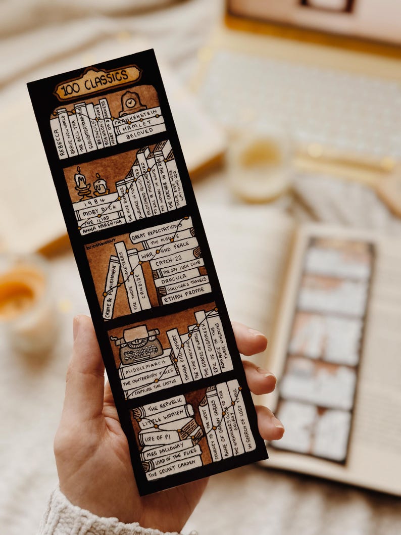May include: A black bookmark with a hand-drawn bookshelf design and the text "100 Classics." The bookmark lists classic literature titles including "Moby Dick," "Hamlet," and "Great Expectations."