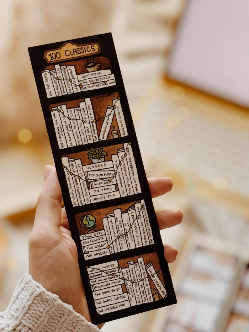 May include: A bookmark with a hand-drawn bookshelf design and the text "100 Classics." The bookmark shows various book titles, including "Pride & Prejudice" and "The Great Gatsby," with a brown background and white book spines.