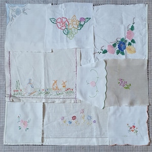 May include: A collection of white fabric squares, each featuring delicate, colorful floral embroidery. The designs include various flowers and scenes, showcasing a vintage aesthetic. The embroidery colors include pink, blue, yellow, and green.