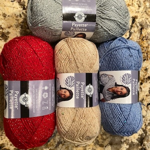 May include: Four skeins of Loops & Threads Payette Paillette yarn in red, beige, blue, and grey. Each skein has a label with the brand name and yarn type.