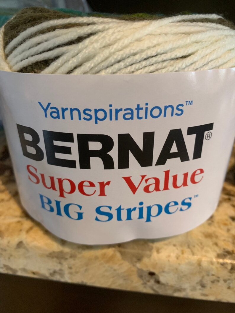 May include: A skein of Bernat Super Value Big Stripes yarn in a green, white, and brown color combination. The yarn is labeled with the Bernat brand name and the yarn weight.