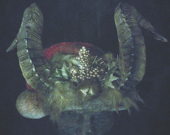 May include: A horned headdress with a red and green base, adorned with gold-colored bells and decorative elements. The horns are large and textured, and the overall design has a festive, fantasy theme.