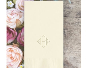 May include: A white linen napkin with a gold embossed monogram "ASR" in a diamond shape.