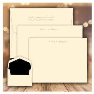 May include: A set of ivory stationery with a cream envelope. The stationery has the address "5412 Cambridge Drive, Dallas, Texas 75207" printed at the top and the name "Kayla Sharp" printed in the center.