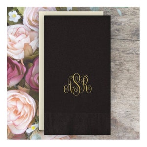 May include: Black paper napkin with a gold monogram "FSR" in a script font.