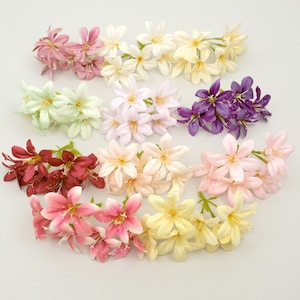 Può includere: Assortimento di fiori artificiali in vari colori, tra cui rosa, bianco, giallo, viola e bordeaux. I fiori hanno un aspetto realistico con goccioline d'acqua, perfetti per composizioni floreali o scopi decorativi.