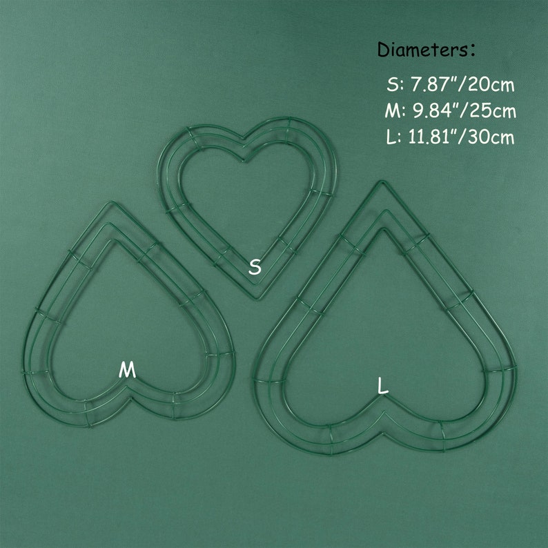 K&ouml;nnte beinhalten: Drei gr&uuml;ne, herzf&ouml;rmige Kranzrahmen aus Metall in verschiedenen Gr&ouml;&szlig;en. Die Rahmen sind mit S, M und L gekennzeichnet. Durchmesser: S: 7,87"/20cm, M: 9,84"/25cm, L: 11,81"/30cm.