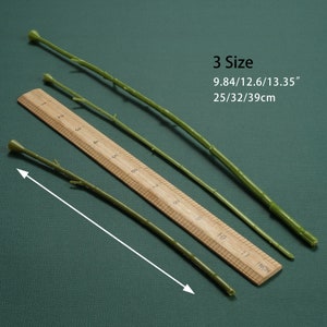 May include: Three green stems of varying lengths, measured against a wooden ruler with inch markings. The stems are 9.84 inches, 12.6 inches, and 13.35 inches long. The text "3 Size" and "25/32/39cm" is printed below the ruler.
