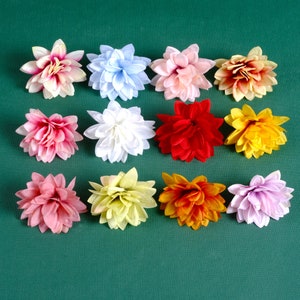 Puede incluir: Doce flores artificiales de varios colores, incluyendo rosa, rojo, amarillo, blanco y morado. Las flores est&aacute;n dispuestas en una cuadr&iacute;cula sobre un fondo verde.