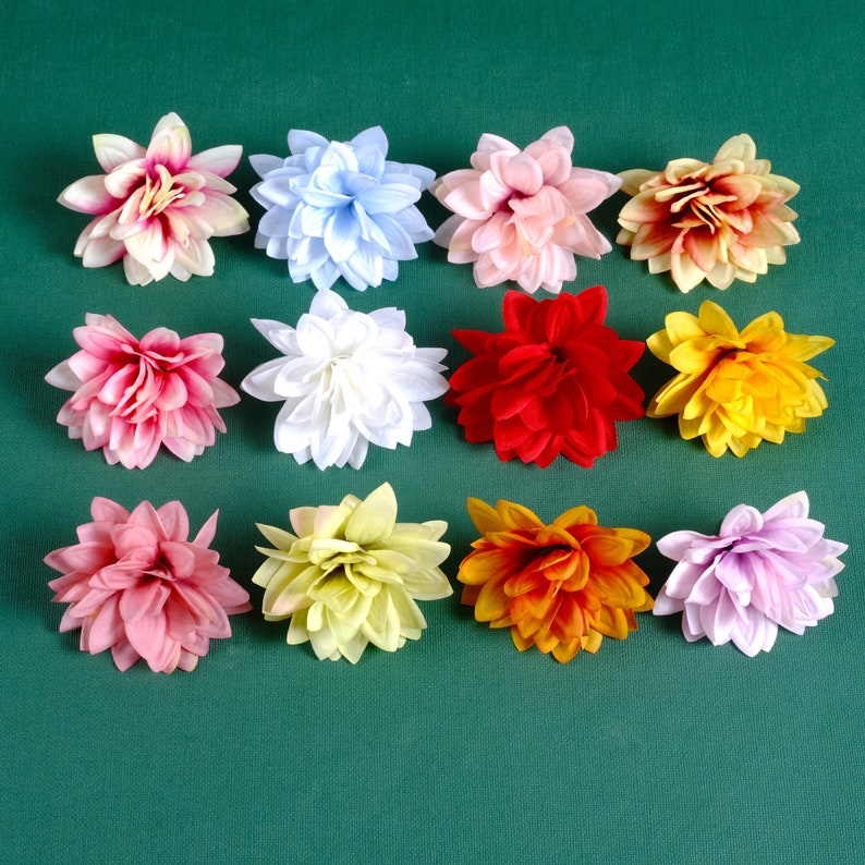 Puede incluir: Doce flores artificiales de varios colores, incluyendo rosa, rojo, amarillo, blanco y morado. Las flores est&aacute;n dispuestas en una cuadr&iacute;cula sobre un fondo verde.