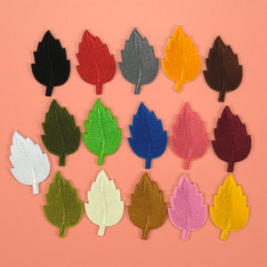 Puede incluir: Surtido de 16 parches termoadhesivos en forma de hojas. Los parches son de varios colores, incluyendo negro, rojo, gris, naranja, marrón, verde, azul, rosa, granate, blanco, verde oliva, crema, dorado y amarillo.