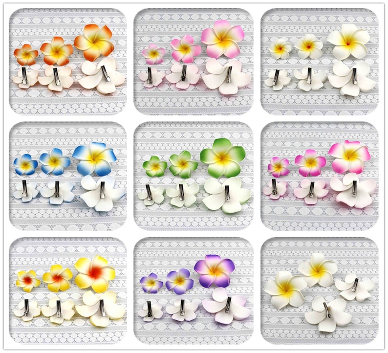 May include: Set of nine hair clips featuring different colored plumeria flowers. Each clip has a white base and a flower with a different color center. The colors include pink, yellow, blue, green, purple, and white.