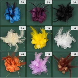 Puede incluir: Nueve broches de flores diferentes con plumas y detalles de perlas. Los broches son de varios colores, incluyendo azul, morado, negro, blanco, amarillo, naranja y rosa.