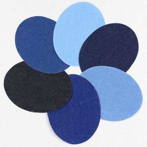 Puede incluir: Seis círculos de tela vaquera en varios tonos de azul, dispuestos en forma de flor.