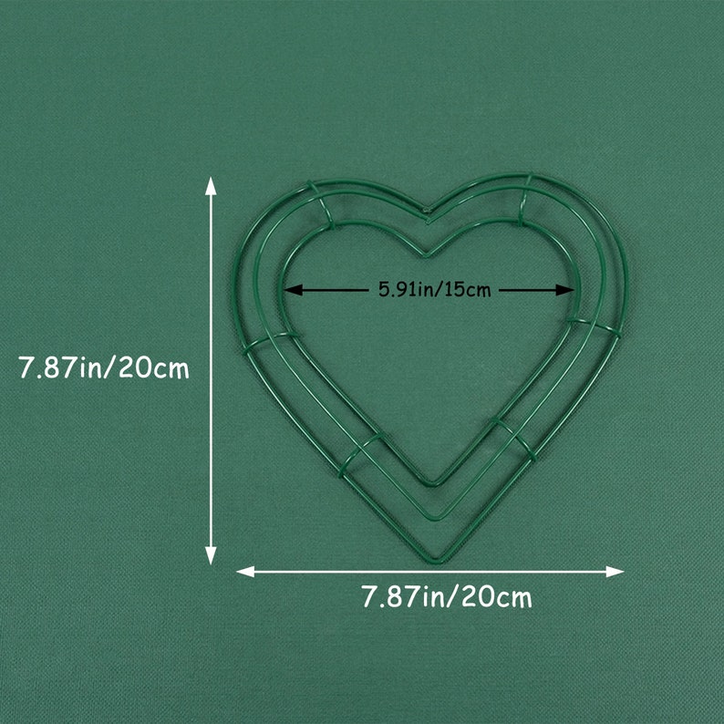 K&ouml;nnte beinhalten: Eine gr&uuml;ne, herzf&ouml;rmige Kranzform aus Metall mit den Ma&szlig;en 20 cm x 15 cm. Die Kranzform besteht aus Draht und hat eine doppelte Schicht.