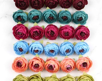 May include: Assortment of 36 artificial flower heads in various colors, including burgundy, teal, light blue, peach, and green. The flowers are arranged in rows, with each row featuring a different color.