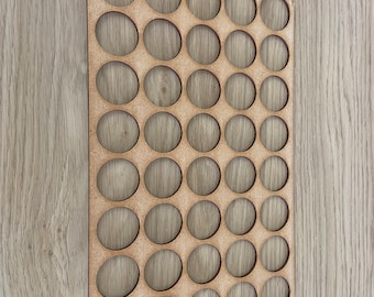 May include: A wooden paint pot holder with 36 circular cutouts. The holder is made of light brown wood and has a smooth finish.