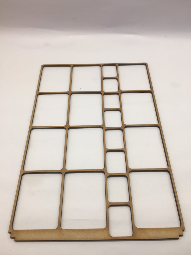May include: A wooden organizer with multiple compartments of varying sizes. The organizer is made of light brown wood and has a rectangular shape.