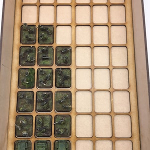 May include: A wooden storage box with a grid of compartments. The compartments are filled with miniature figures and vehicles, including soldiers, guns, and trucks. The figures are painted in camouflage colors.
