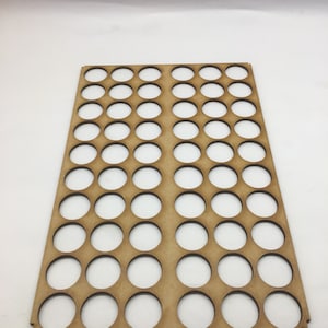 May include: A wooden paint pot holder with 48 round holes. The holder is light brown and has a smooth surface.