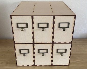 May include: A wooden box with six drawers, each with a metal pull handle. The box is made of light wood and has a natural finish.