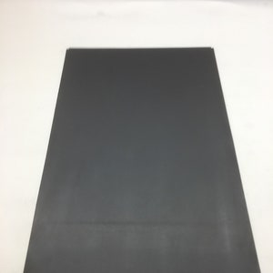 May include: A dark gray rectangular sheet of paper.
