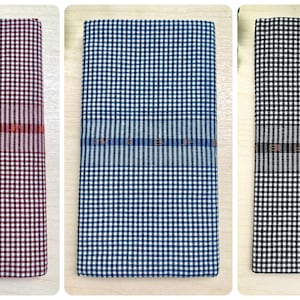 以下が含まれることがあります： 異なる色のチェック柄の布製タオルが4枚あります。ワインレッド、ブルー、ブラック、ライトブルーです。各タオルには、中央に細い織り込まれたストライプがあります。