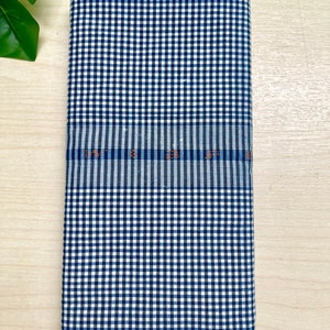 Puede incluir: Una tela a cuadros azules y blancos con una franja azul y blanca en el medio. La tela tiene el texto "LWT S 25" impreso en la franja.