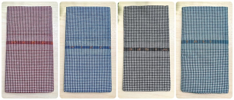 Puede incluir: Cuatro toallas de tela a cuadros en diferentes colores: burdeos, azul, negro y azul claro. Cada toalla tiene una fina franja tejida en el medio.